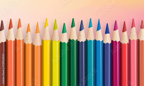 array of colored pencils on pastel background