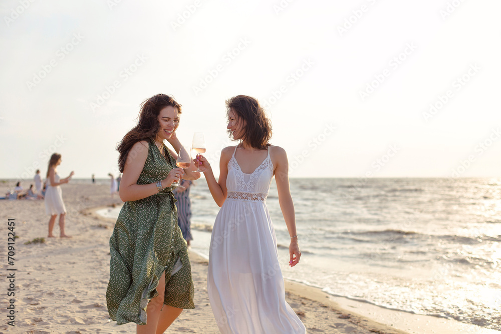 Happy adult women with wine resting on beach Happy adult women with wine resting on beach