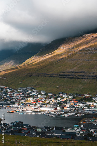 sunset over the fjord of faroe islands on a moody day with the town of klaksvik photo