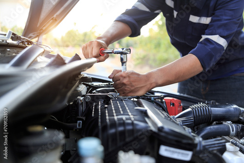 Automobile mechanic repairman hands repairing a car engine automotive workshop with a wrench, car service and maintenance,Repair service. © A Stockphoto