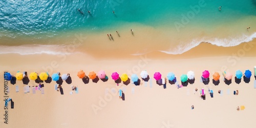 Aerial view of colorful umbrellas on sandy beach.