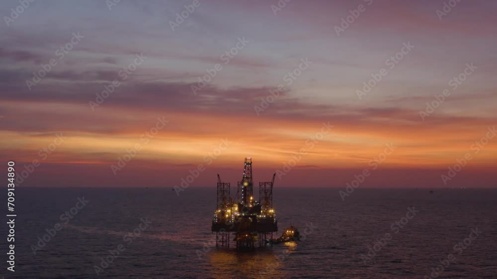 Aerial view of silhouette offshore jack up drilling rig during sunset - oil and gas industry Aerial view of silhouette offshore jack up drilling rig during sunset - oil and gas industry