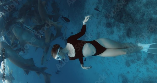 Attractive woman freediver dives and swimming with Nurse sharks and fishes in blue ocean in the Maldives. photo