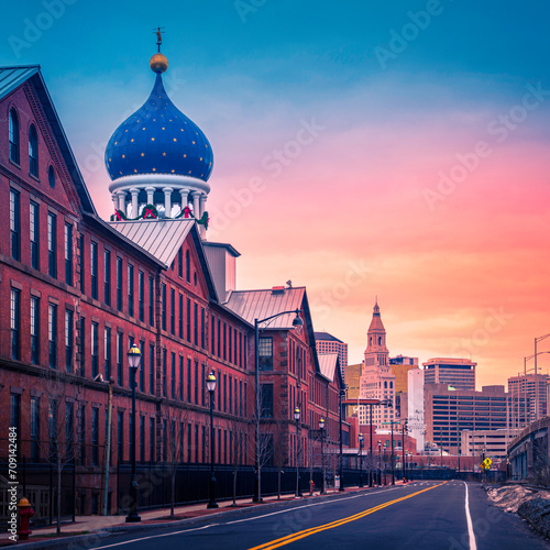 Sunrise over Hartford City Skyline and historic landmark buildings along the I-91 Interstate Highway, a view from Charter Oak Landing of Connecticut River, USA, a snow-covered winter landscape photo