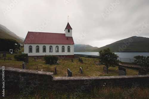 church with red roof in the small village by the fjord