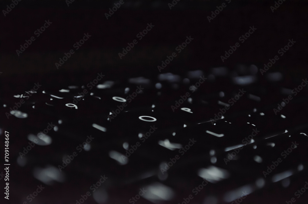 Laptop keyboard with light on table.