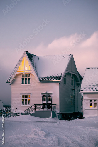 house in the snow in norway under a pink winter sky