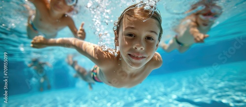 Children swimming underwater in pool. photo