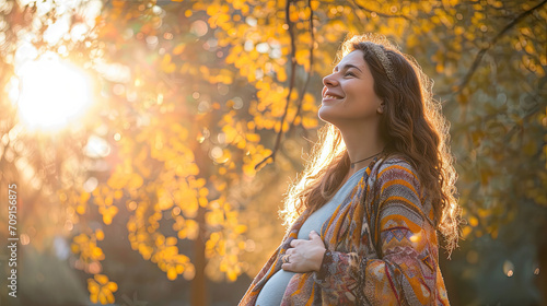 Happy pregnant woman standing in the park