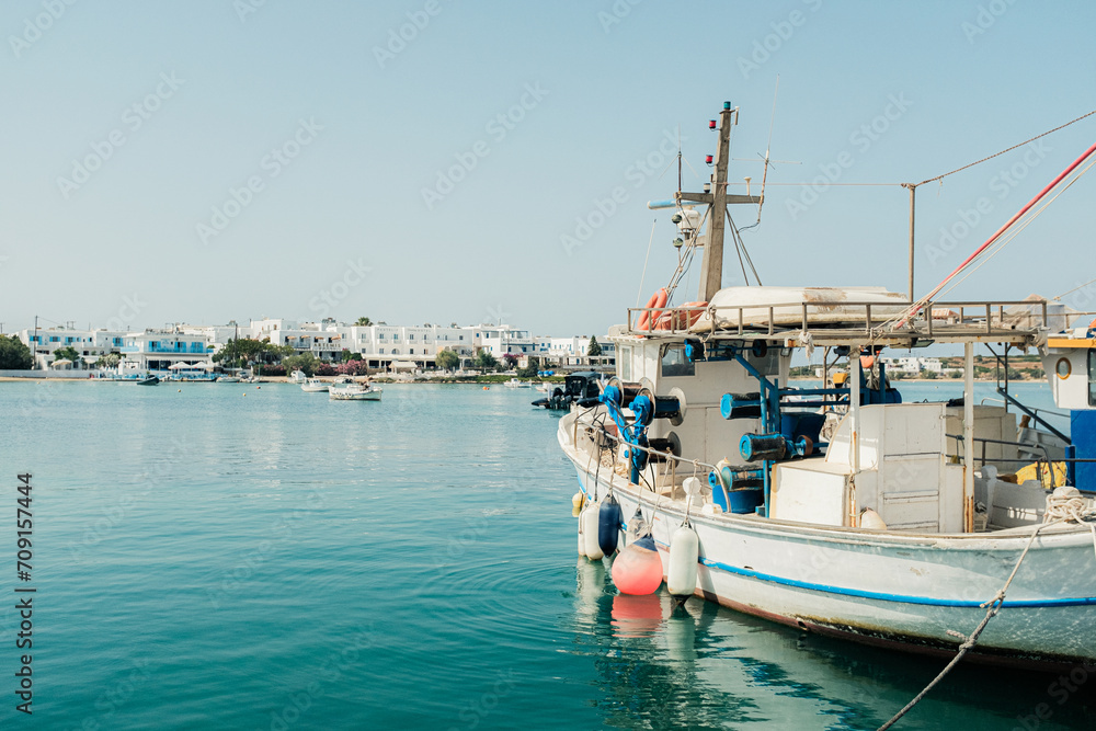 Fishing boat in the port of Antiparos, Greece with the beachfront in the background.