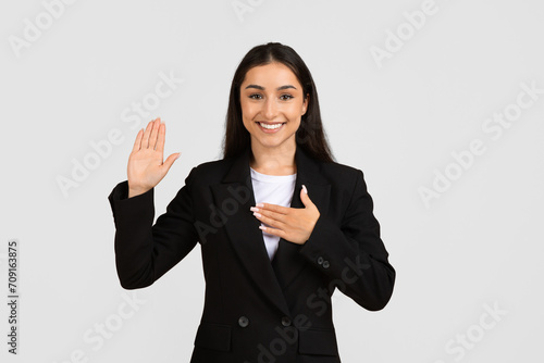 Canvastavla Sincere european businesswoman making pledge or swearing an oath with her right