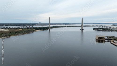 The Dames Point Bridge in Jacksonville  Florida  captured in daylight with cars driving over and water underneath.