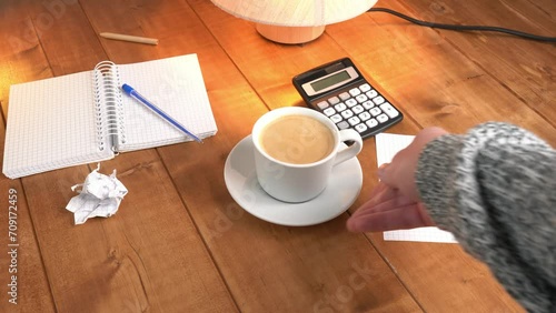 A man serves coffee on a wooden table.
