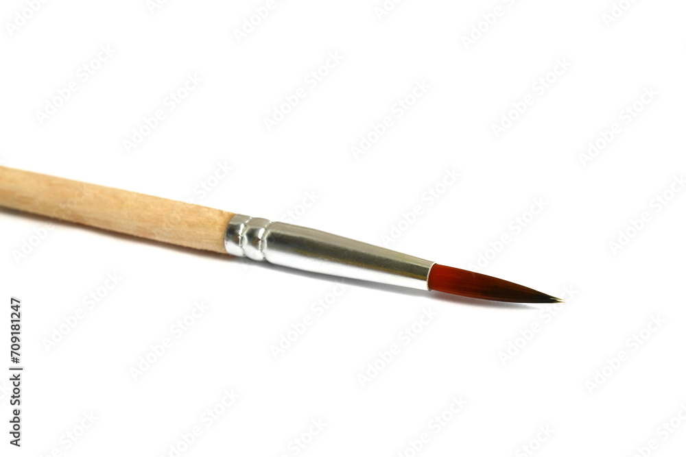  A wooden brush for painting lies on a white background.