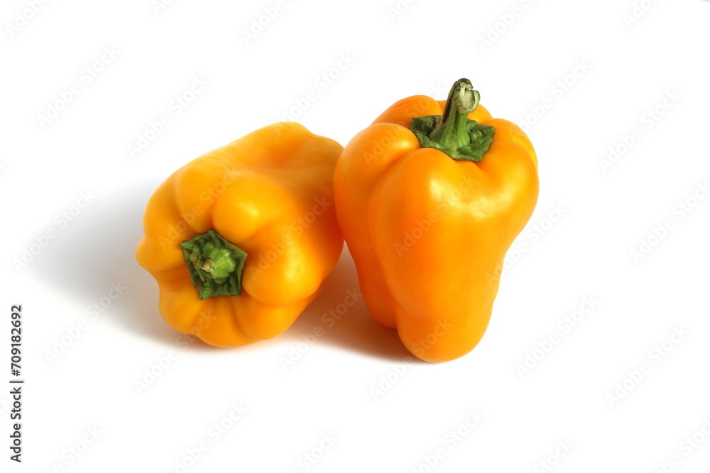 Two yellow peppers lie on a white background. Two yellow peppers lie on a white background.
