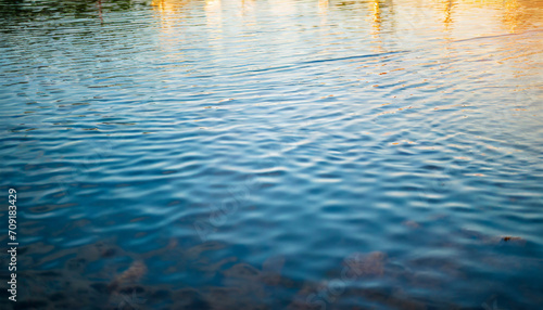 Crystal-clear water surface reflecting vibrant blue sky, symbolizing purity, tranquility, and serenity. Ideal for concepts of clarity and calmness