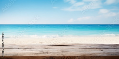 Blurred blue sea and white sand beach backdrop with a wooden tabletop.