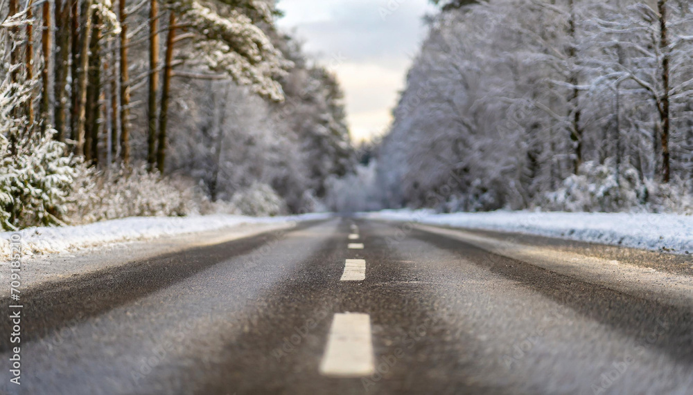 Snow-covered winter landscape with winding asphalt road through serene forest, capturing the tranquil beauty of a cold season journey Snow-covered winter landscape with winding asphalt road through serene forest, capturing the tranquil beauty of a cold season journey
