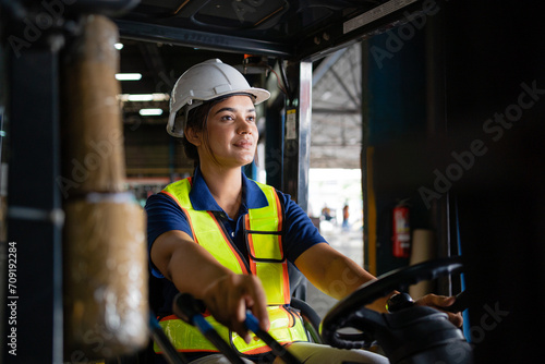 female factory worker. female forklift operator working in a warehouse. Portrait of young Indian woman driver sitting in forklift and smiling working in warehouse. photo