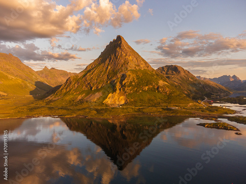 The Volandstind Mountain in Lofoten, with its reflection in the calm sea, at sunset, near Ramberg