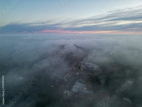 Aerial photograph capturing the ethereal beauty of a city shrouded in mist during twilight © Wirestock