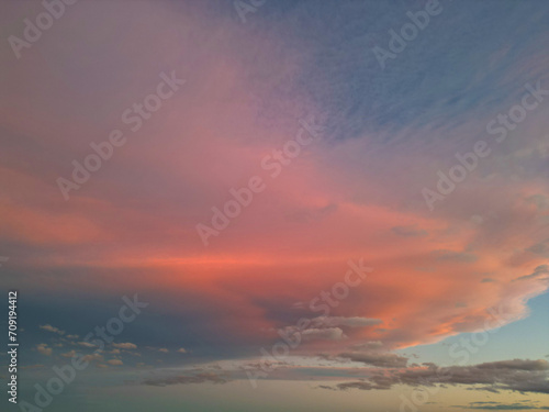 an evening sky with pink and blue clouds over the sea