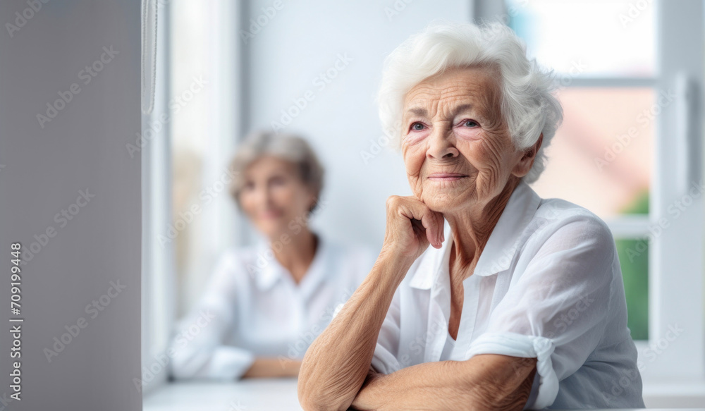 Serene senior lady lost in thought, looking out of a bright window. Serene senior lady lost in thought, looking out of a bright window.