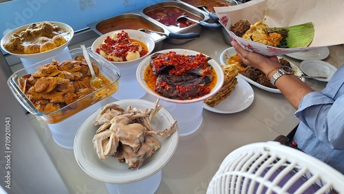Warung Nasi Padang, Padang rice curry one of the most famous meals to be associated with Indonesia, a mix of rice and side dishes, like chicken pop, beef rendang, mix vegetables and egg balado. photo