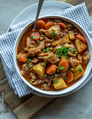 Healthy chicken stew with vegetables in a bowl with spoon
