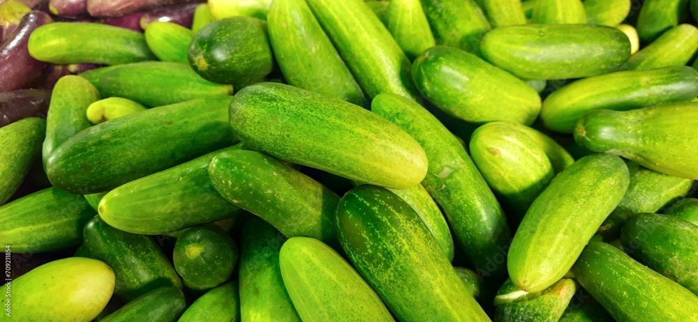 Close up of heap cucumbers placed on stall of market ready to sold. Cucumber background Close up of heap cucumbers placed on stall of market ready to sold. Cucumber background