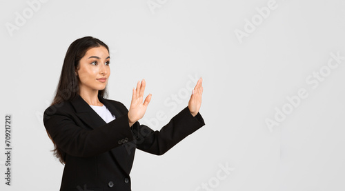 Confident caucasian businesswoman touching something invisible with her hands, free space, panorama