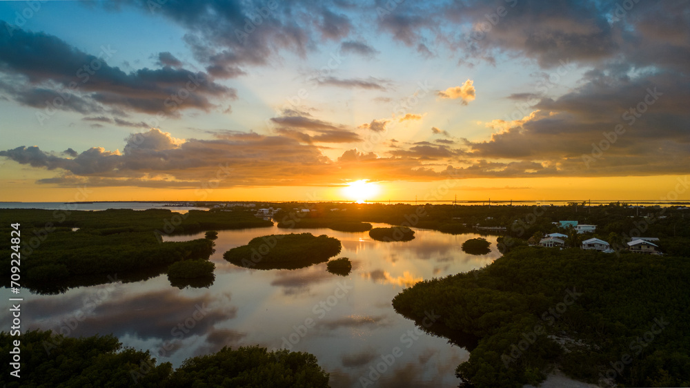 Sunset over Rock Harbor mangroves with reflection on water in Florida Keys Sunset over Rock Harbor mangroves with reflection on water in Florida Keys