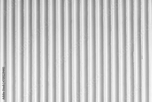 Old white concrete background wall with vertical line ribbed. Stripes as a texture. photo