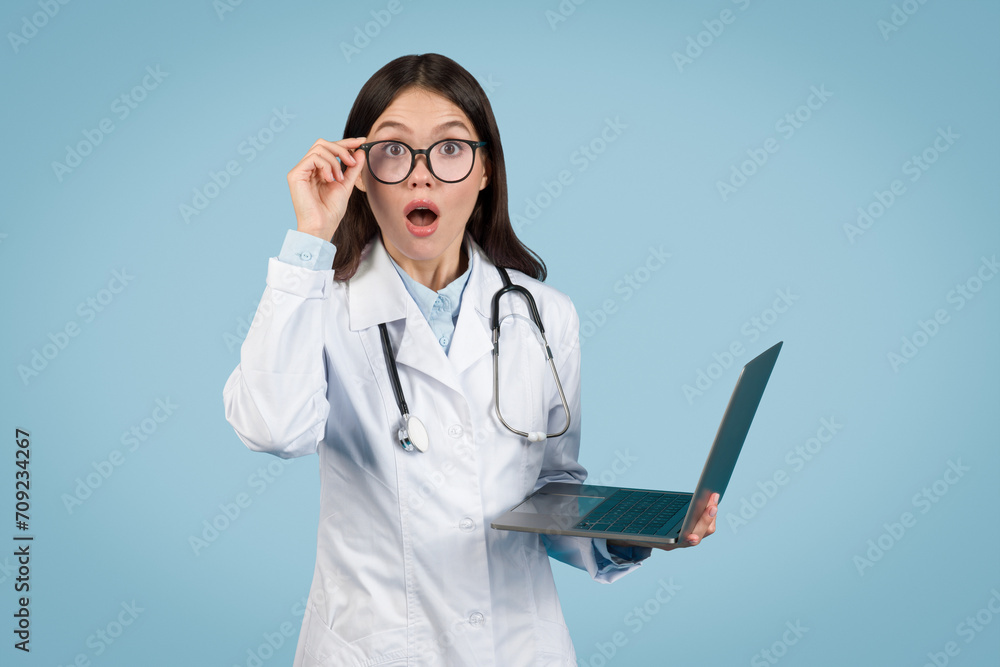 Surprised doctor with laptop, reacting to medical data Surprised doctor with laptop, reacting to medical data