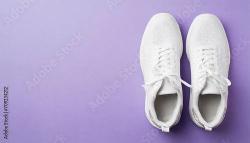 Top view of white sneakers on isolated purple background with copy space