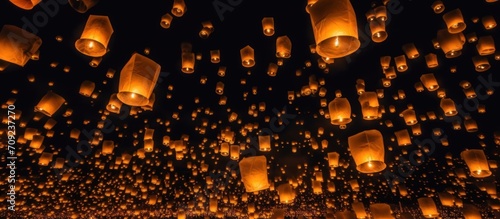 Chinese sky lanterns floating in a dark night sky photo