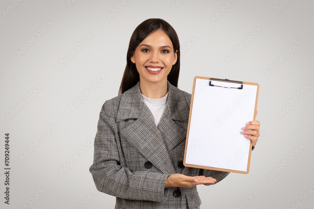 Smiling woman presenting blank clipboard for design Smiling woman presenting blank clipboard for design