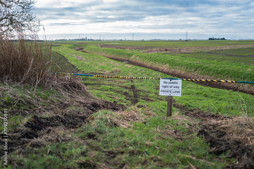 Shallow focus of a Private Land sign in rural East Anglia. Known for trespassing due to the nearby public footpath, the land owner has now blocked off the entrance.