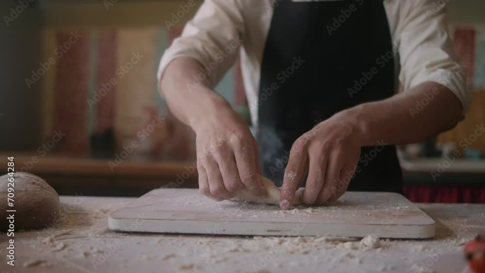 Close up of bakery chef applying flour on dough, man kneading dough, making bread using traditional recipe. Lifestyle healthy eating and traditional bakery concept Close up of bakery chef applying flour on dough, man kneading dough, making bread using traditional recipe. Lifestyle healthy eating and traditional bakery concept