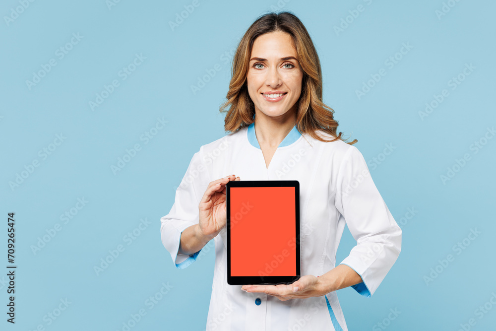 Female doctor woman wear white medical gown suit work in hospital clinic office hold show blank screen digital tablet pc computer isolated on plain blue background studio Health care medicine concept Female doctor woman wear white medical gown suit work in hospital clinic office hold show blank screen digital tablet pc computer isolated on plain blue background studio Health care medicine concept