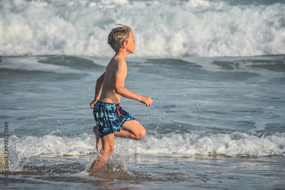 boy running in water, knysna, south africa