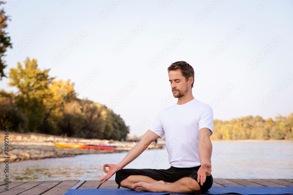 Fototapeta premium Full length of man practicing yoga outdoor