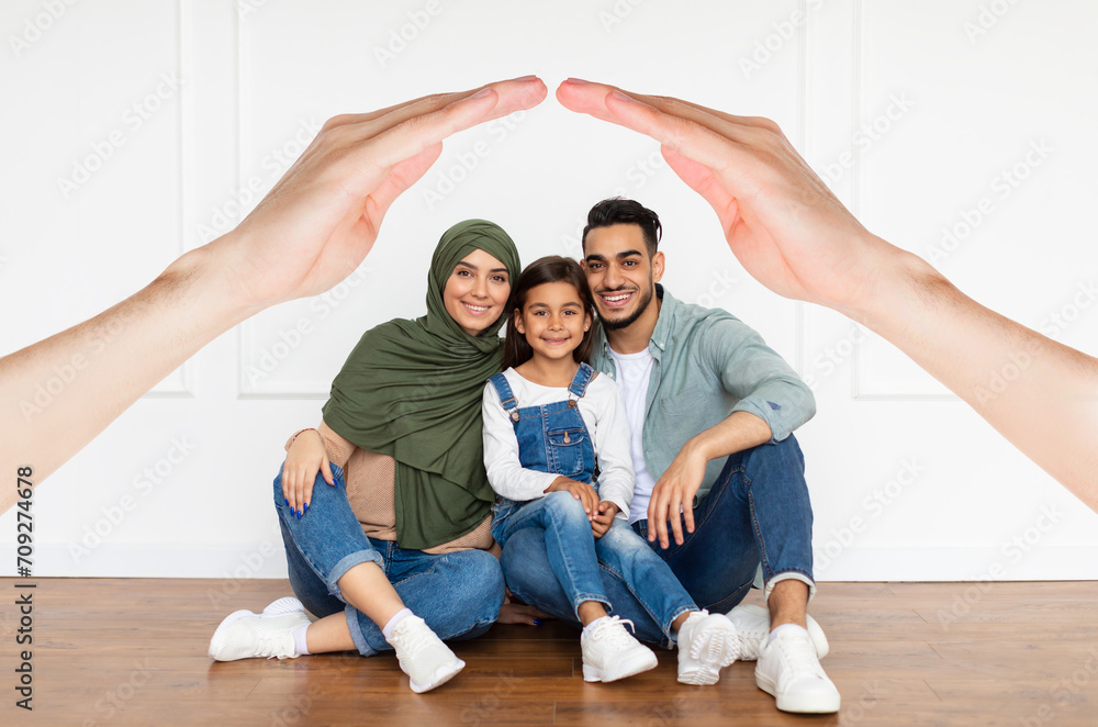 Smiling muslim parents posing with their smiling preteen kid daughter Smiling muslim parents posing with their smiling preteen kid daughter