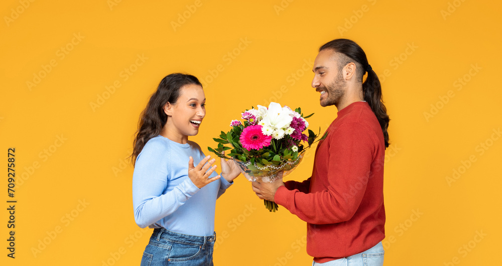 Two cheerful people loving couple exchange bouquet of mixed flowers Two cheerful people loving couple exchange bouquet of mixed flowers