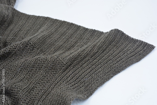 Beautiful and stylish knitted from brown, woolen thread with a beautiful pattern, an interesting pattern arranged on a white background.