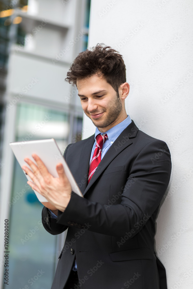 Smiling businessman using tablet outdoors Smiling businessman using tablet outdoors