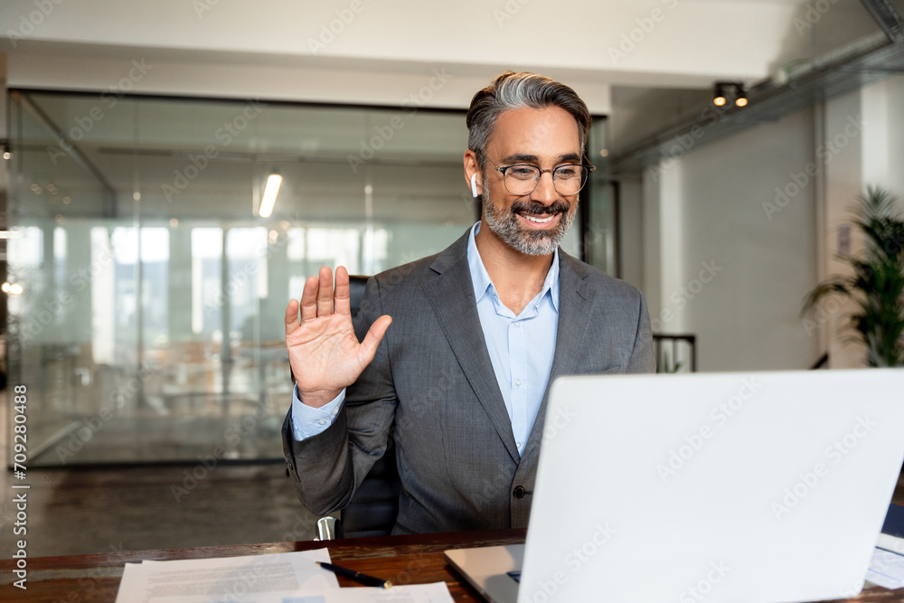 Middle-age Hispanic man using computer remote for business studying, watch online virtual webinar training meeting, video call. Smiling mature Indian or Latin businessman working on laptop in office. Middle-age Hispanic man using computer remote for business studying, watch online virtual webinar training meeting, video call. Smiling mature Indian or Latin businessman working on laptop in office.
