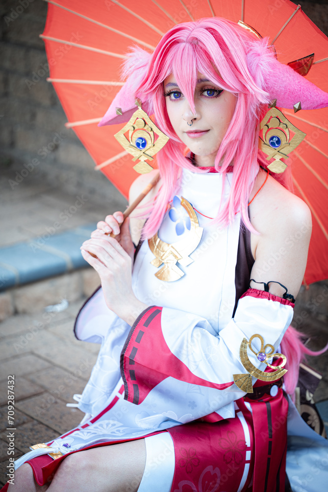 Female cosplayer in a pink anime costume wearing pink hair Female cosplayer in a pink anime costume wearing pink hair