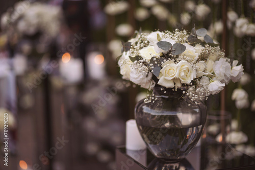 View of elegant expansive white flowers and andles decoration for wedding party. the wedding ceremony in the open air of fresh flowers, with candles. Luxury and beautiful wedding decor. Decor details. photo