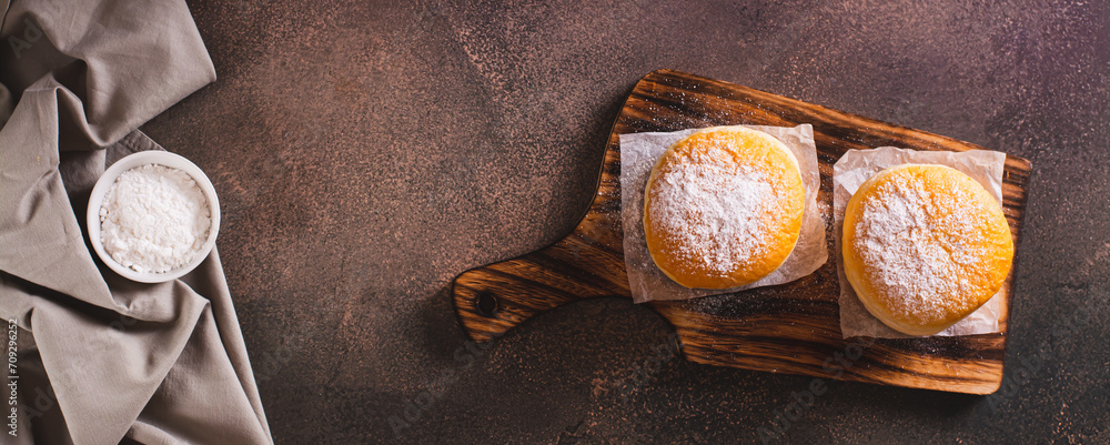 Fresh donuts with powdered sugar and sweet filling on a plate on the table top view web banner - obrazy, fototapety, plakaty 